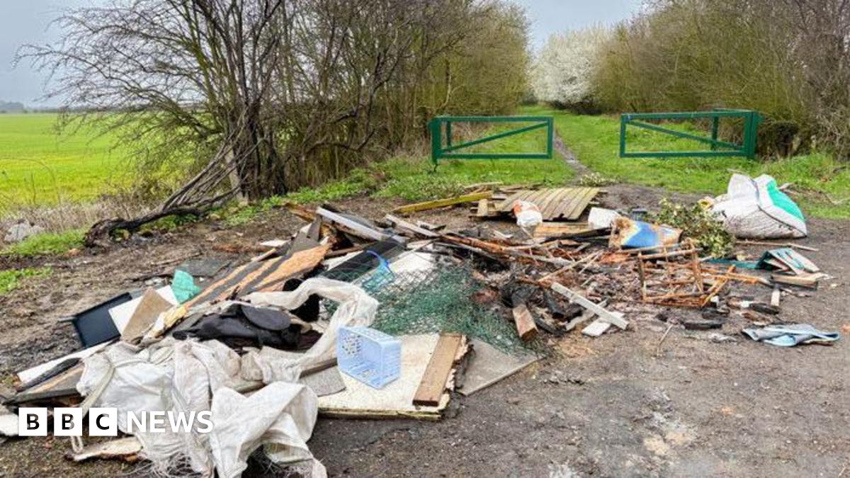 A pile of mixed and burnt rubbish has been fly-tipped and left down a country lane.