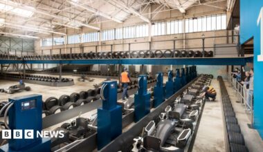 Wide shot of e-karts lining the inside of a hangar building.