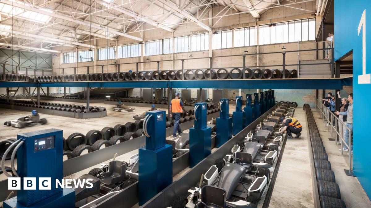 Wide shot of e-karts lining the inside of a hangar building.