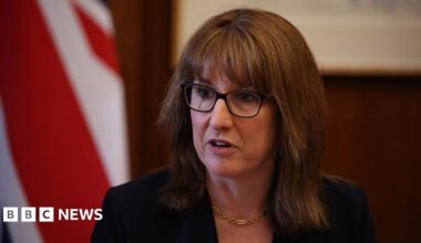 UK Chancellor Rachel Reeves wearing glasses and a black suit jacket.