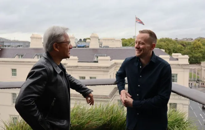 Joshua Payne, founder of NScale, speaking with another man on a rooftop with the Union Jack flag visible in the background.