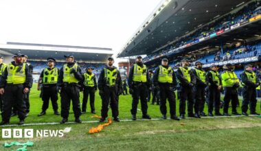 A line of police oficers on the pitch at Ibrox.