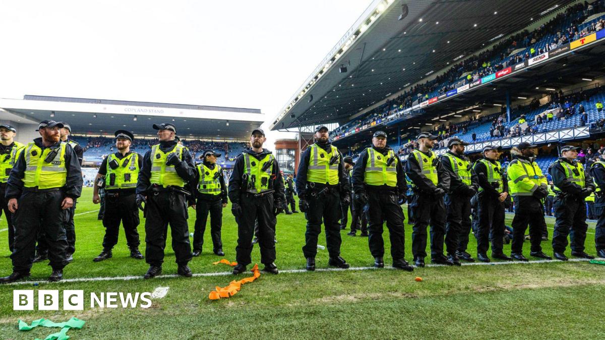 A line of police oficers on the pitch at Ibrox.