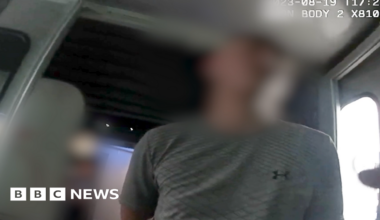 Arooj Shah, with shoulder-length dark hair and wearing a black top, speaks in a BBC TV studio.