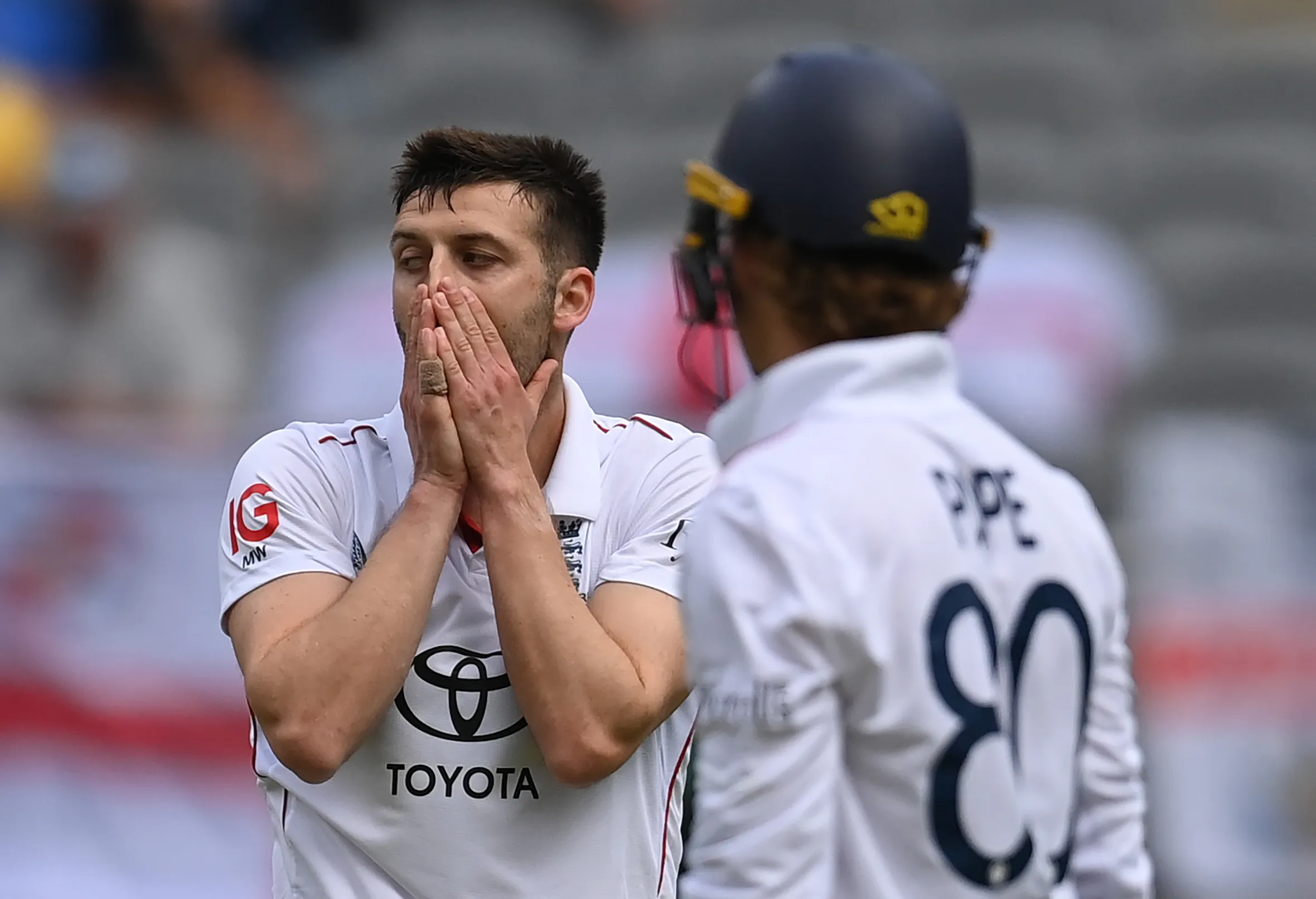 Mark Wood of England reacts with his hands over his face after Travis Head hit a six during a cricket match.