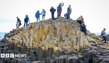 Giant's Causeway with people climbing over the rocks.