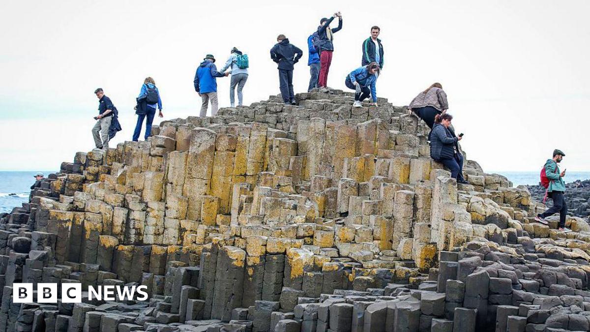 Giant's Causeway with people climbing over the rocks.