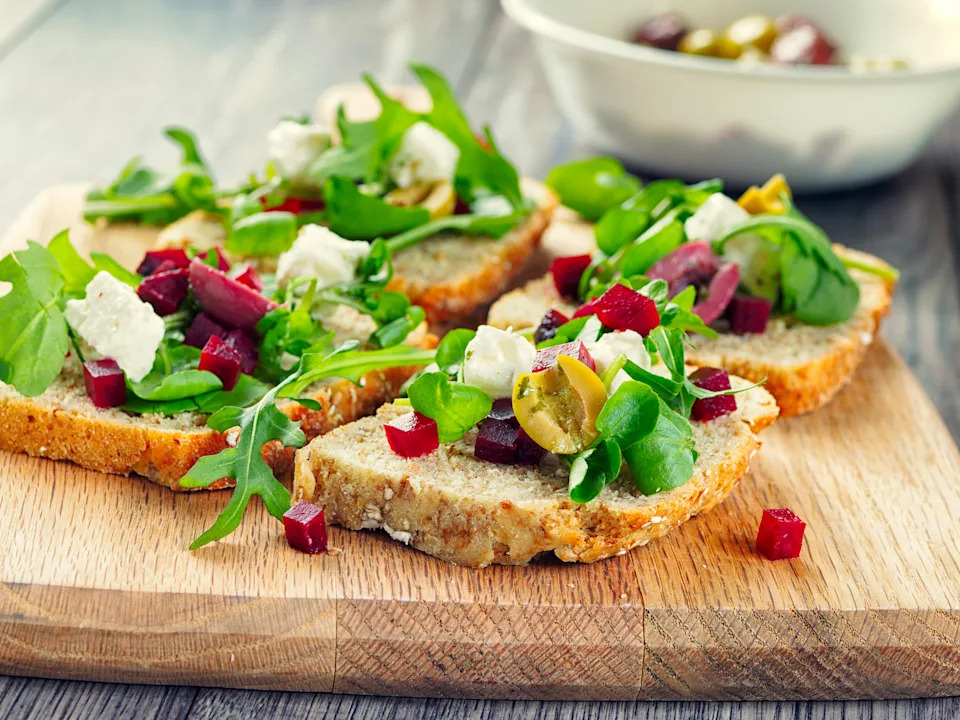 Home made healthy vegetarian open sandwich,made by fine diced cooked beetroot,olives and feta cheese,rocket,water cress leaves on Irish wheaten bread