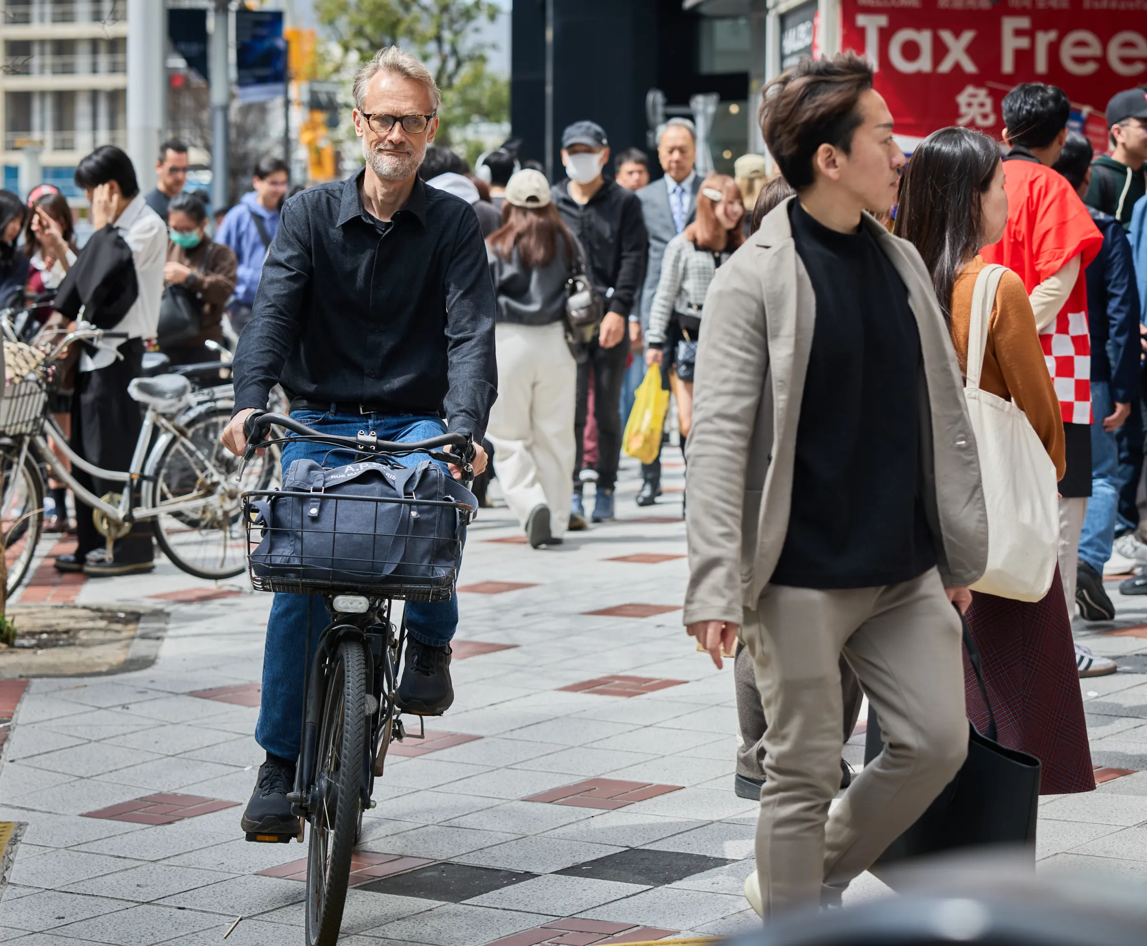 Man on a bicycle in a busy street in Tokyo, Japan.