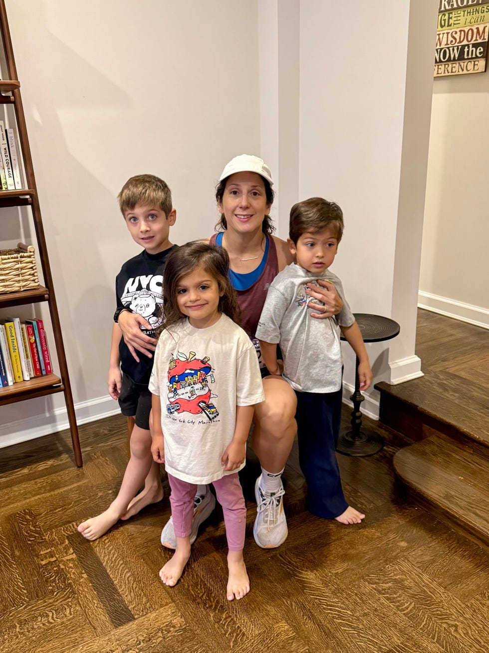 Group of four children and an adult female sitting together indoors.