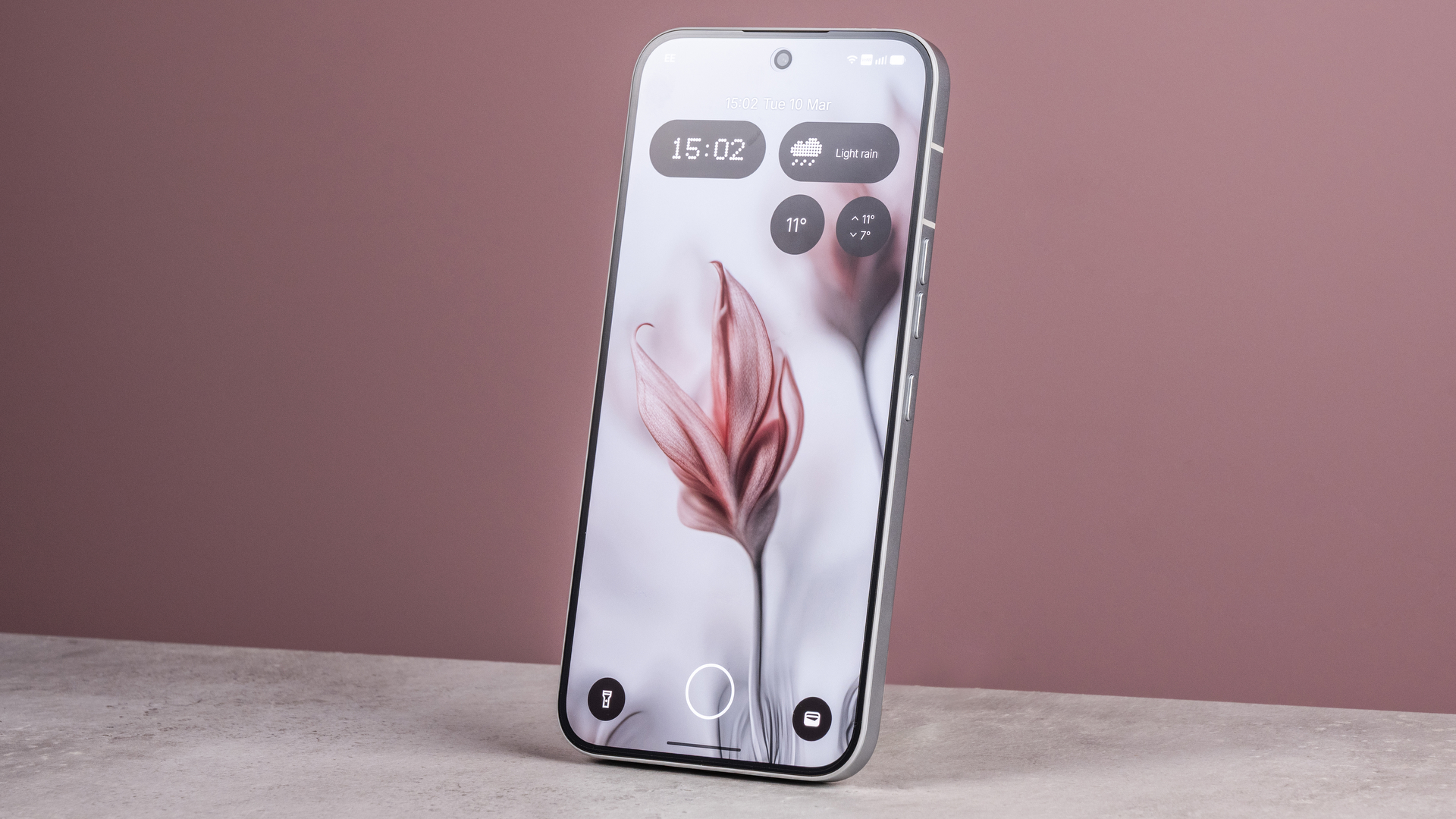 The Nothing Phone (4a) Pro's home screen featuring an AI image of flowers, in front of a pink background.