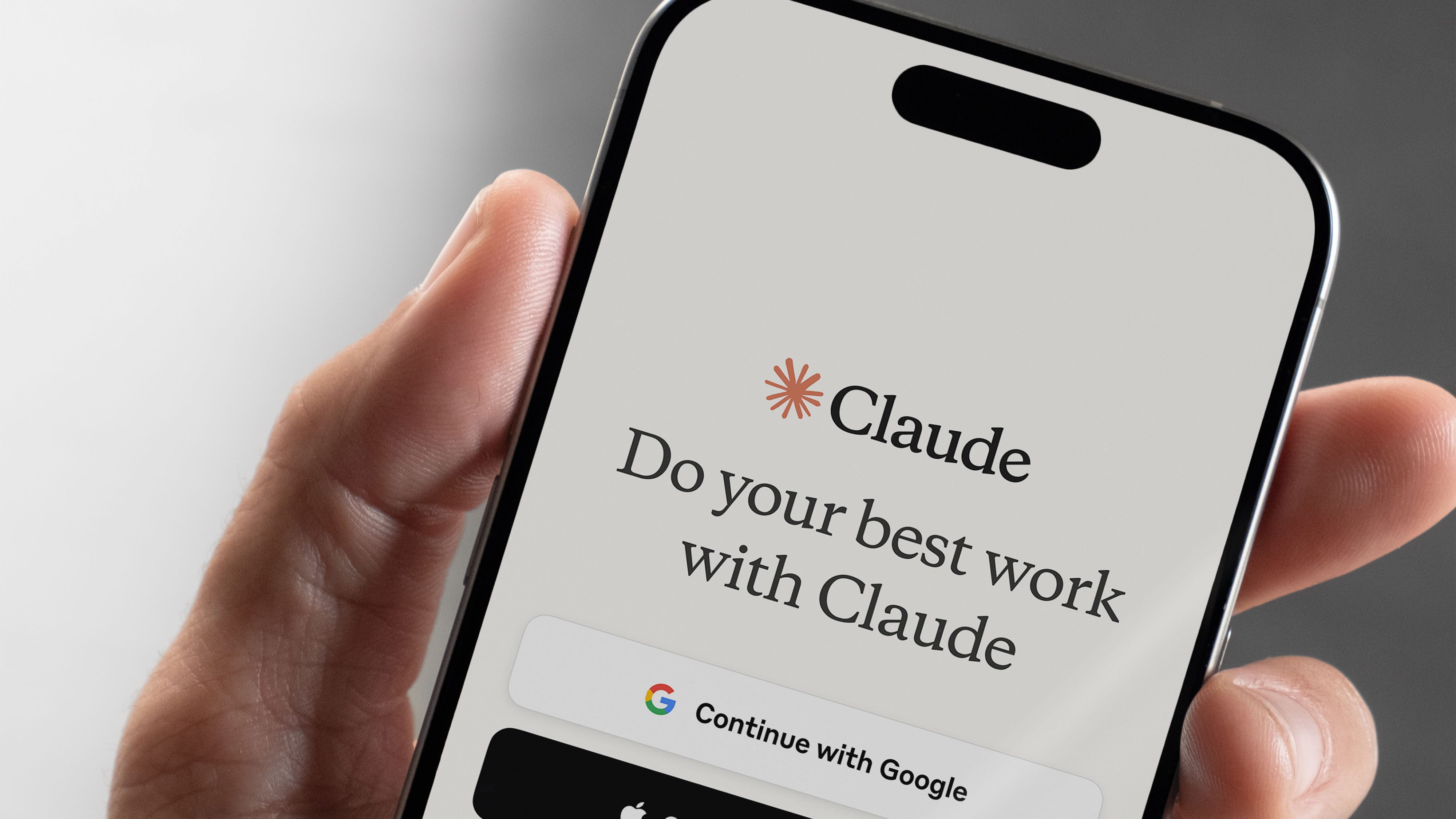 Mobile phone displaying a Claude login screen.