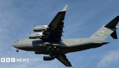 A large grey military jet aircraft against a blue sky