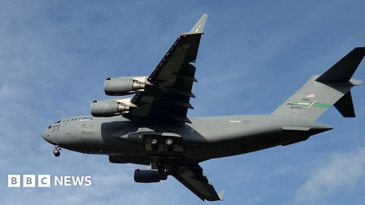A large grey military jet aircraft against a blue sky