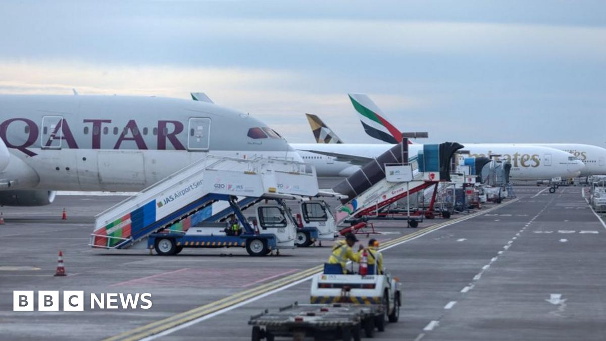 Emirates and Qatar Airways aircraft on the tarmac at I Gusti Ngurah Rai International Airport in Bali, Indonesia, after flight cancellations