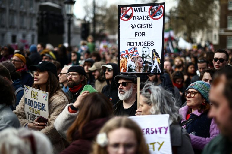 Protesters holding placards gather ahead of speeches after a march against the far right, organised by the Together Alliance, in central London on March 28, 2026. (Photo by Henry NICHOLLS / AFP)