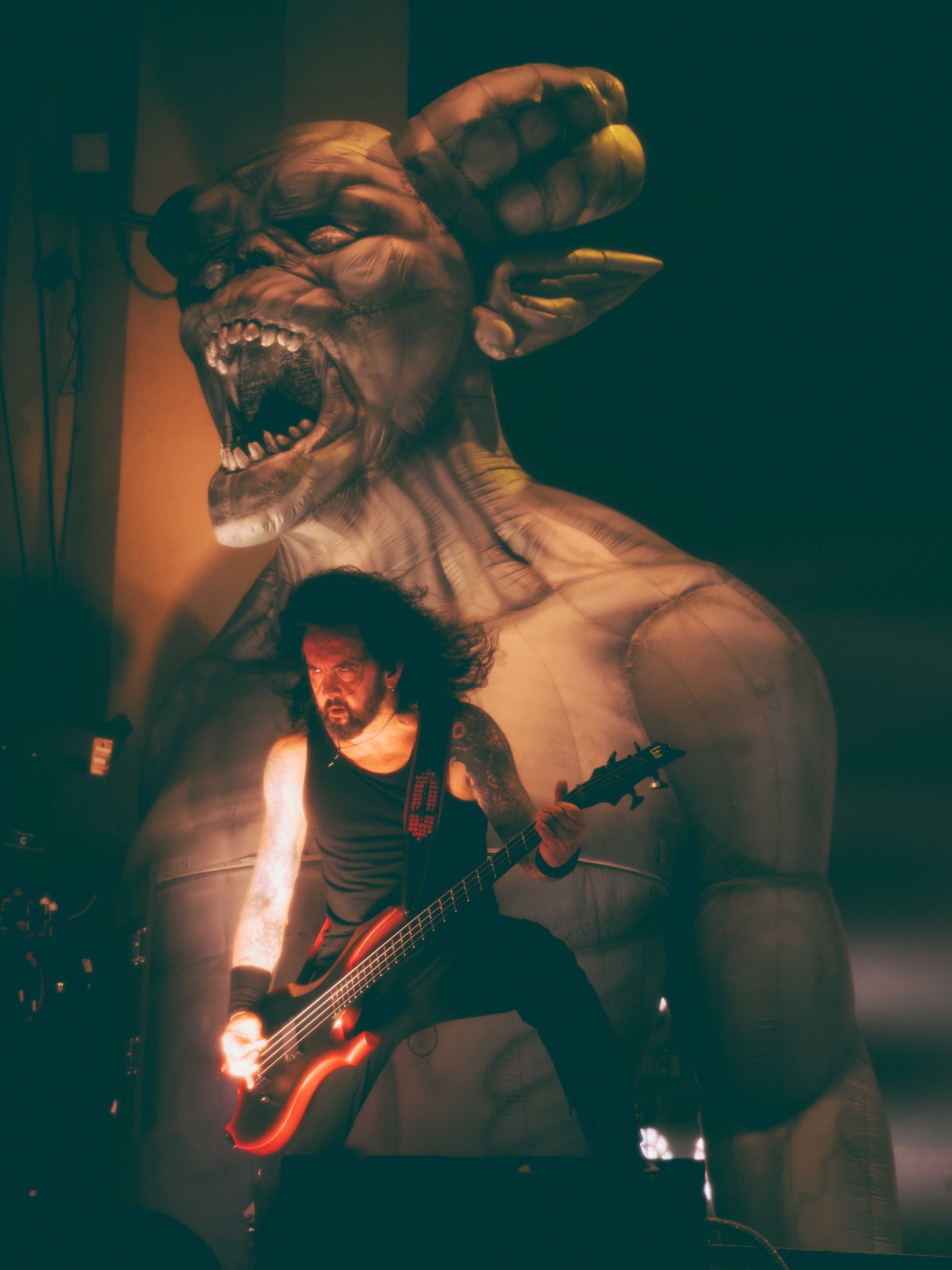 Frederic Leclercq of Kreator onstage with an inflatable demon behind him