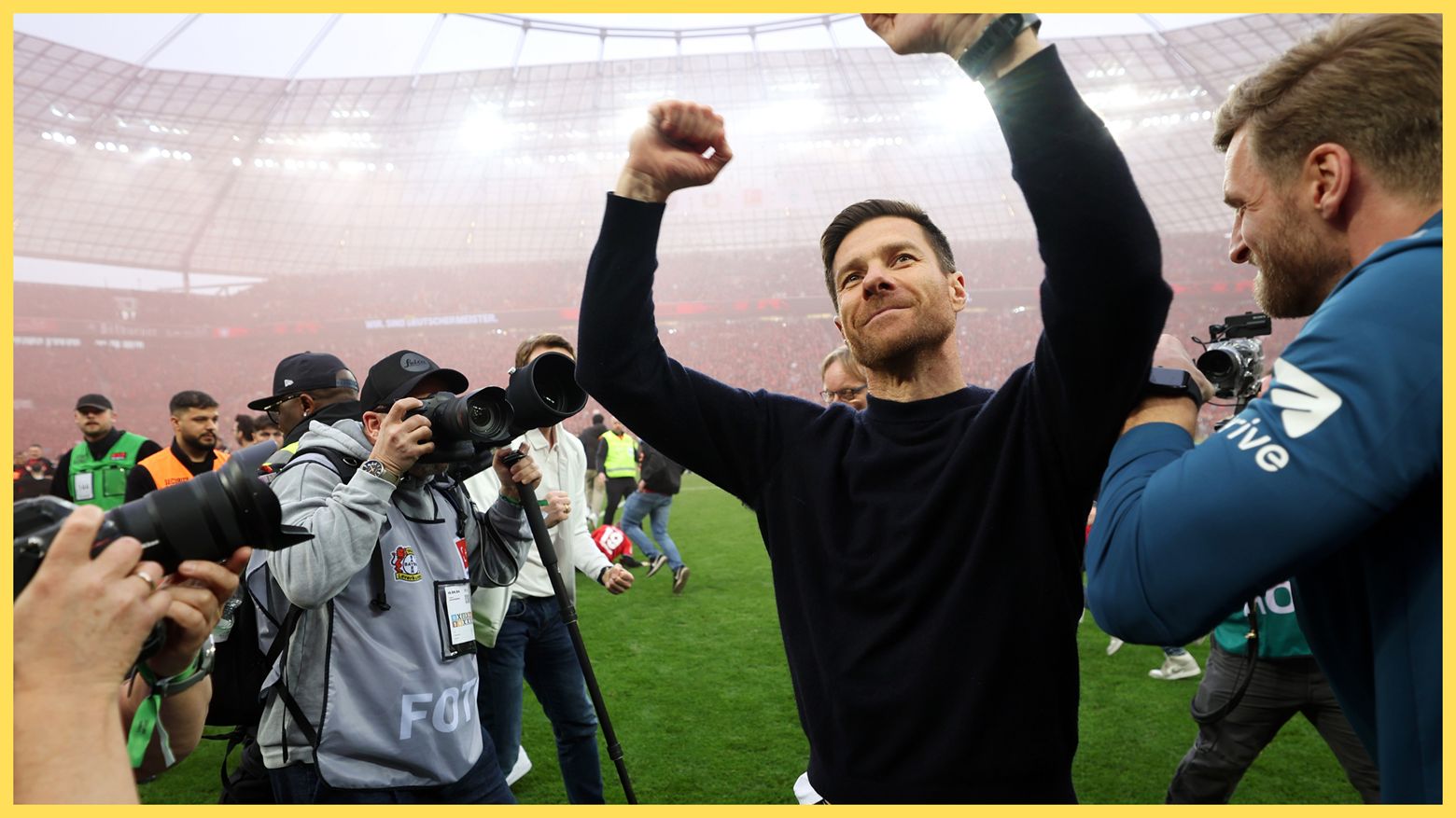 Xabi Alonso throws his arms in the air in celebration.
