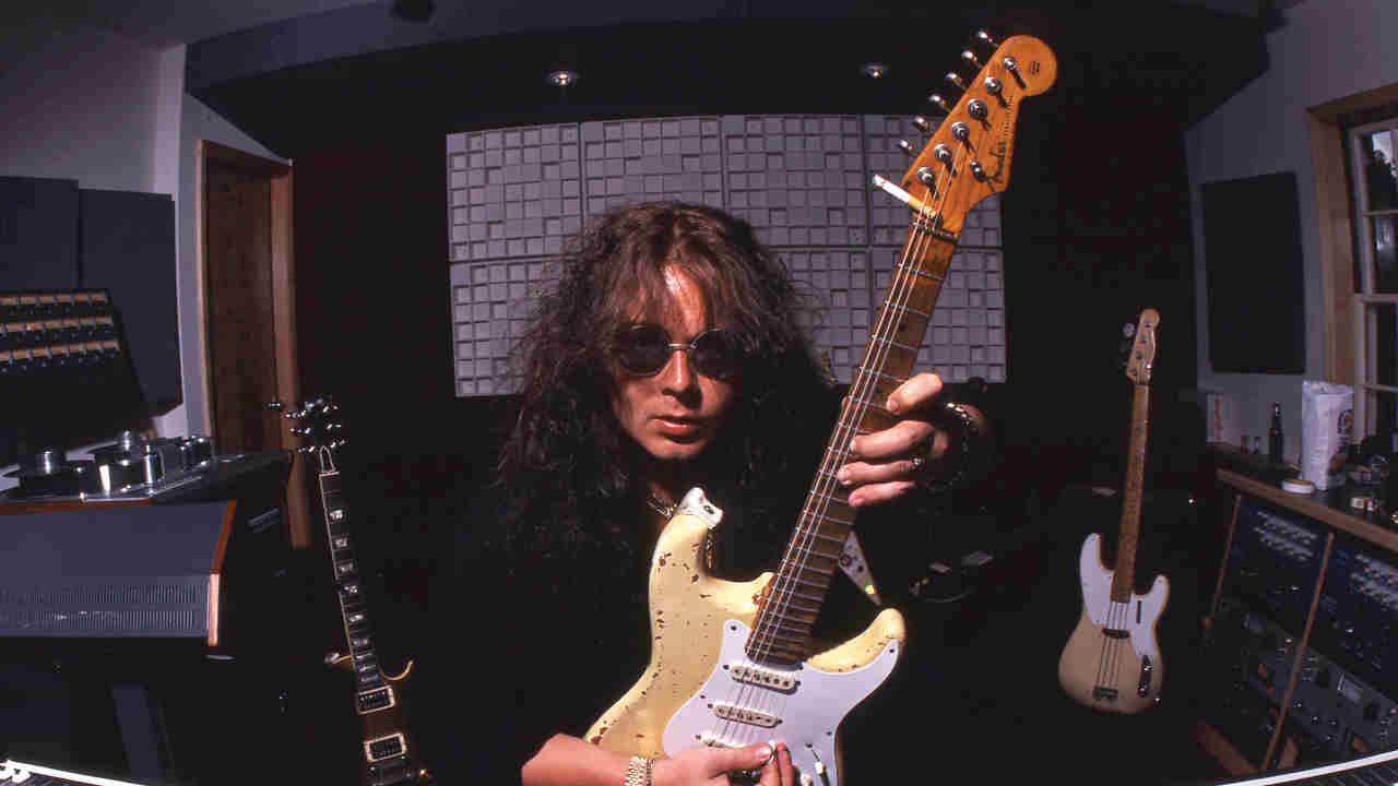 Yngwie Malmsteen posing for a photograph with a guitar