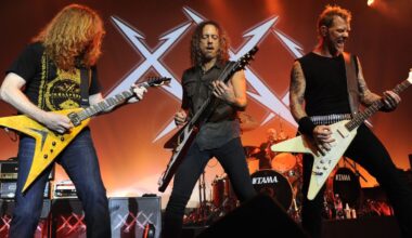 James Hetfield and Kirk Hammett of Metallica playing guitar onstage with Dave Mustaine of Megadeth