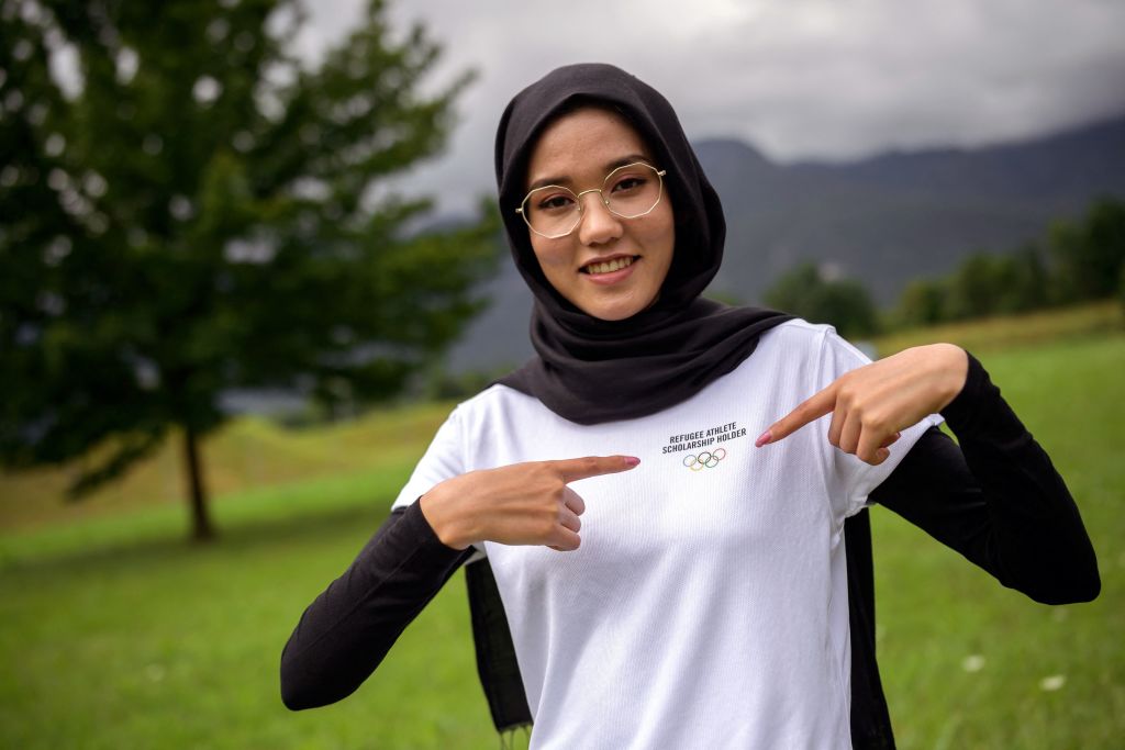 Afghan refugee road cyclist Masomah Ali Zada poses with her tshirt adorned with the Olympics Rings at the World Cycling Centre CMC in Aigle on July 1 2021 as she prepares to compete at the Tokyo Olympics The 24yearold cyclist had stones thrown at her and was physically attacked in her homeland for daring to don sportswear and ride a bicycle in public She will compete at the 2020 Games for the Olympic Refugee Team and feels a duty to represent the 82 million people around the world forced to flee their homes either inside their countries or as refugees She also sees herself as a representative of women living in repressive societies and sportswomen who wear a headscarf TO GO WITH AFP STORY BY ROBIN MILLARD Photo by Fabrice COFFRINI AFP TO GO WITH AFP STORY BY ROBIN MILLARD Photo by FABRICE COFFRINIAFP via Getty Images
