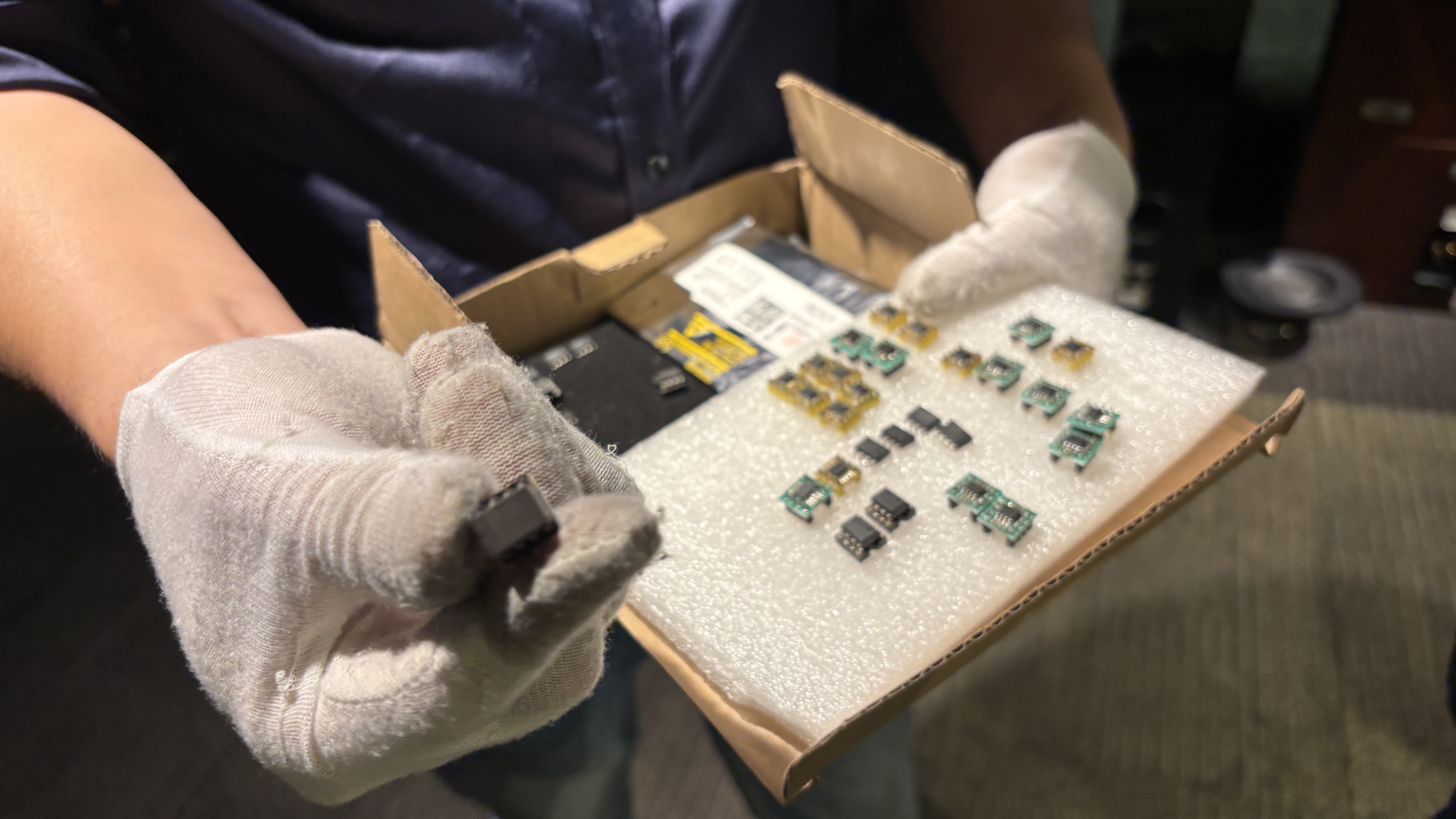 A man holding a box of electronics components