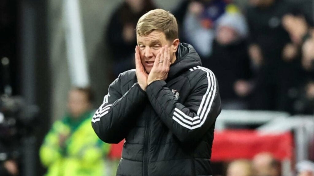 Newcastle United manager Eddie Howe stands with his hands on his face during a game.