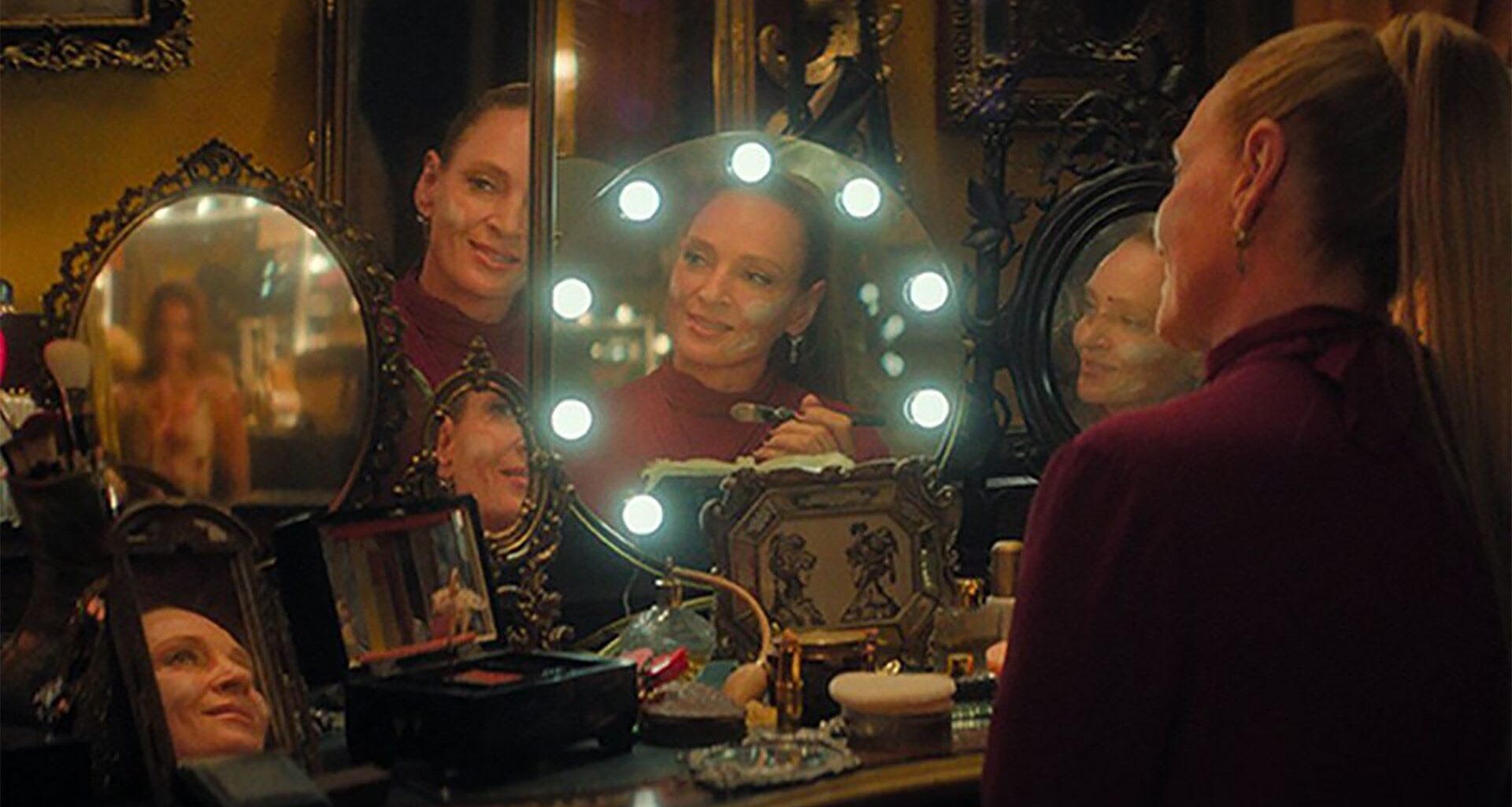 Uma Thurman's Devora Kasimer sitting at a make up table looking at a group of bloody ballerinas in her mirror