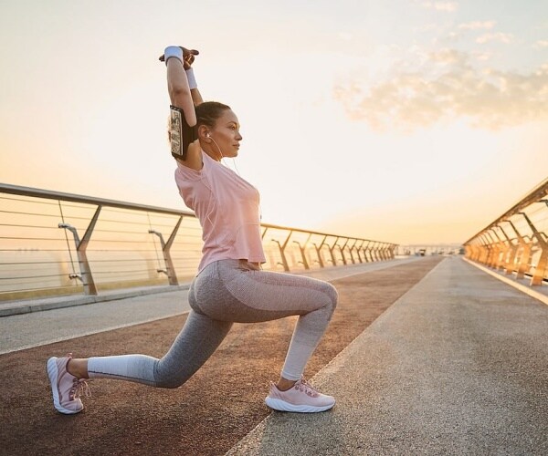 woman stretching before an early morning run