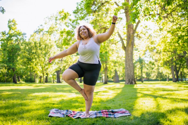 Young woman practicing yoga outdoors in park