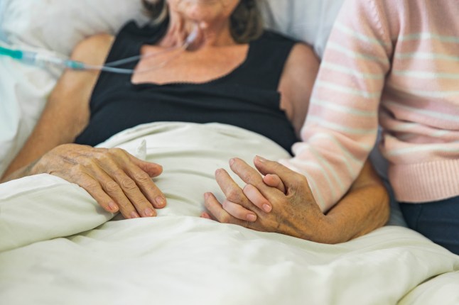 Young girl holds the hand of her ill grandmother