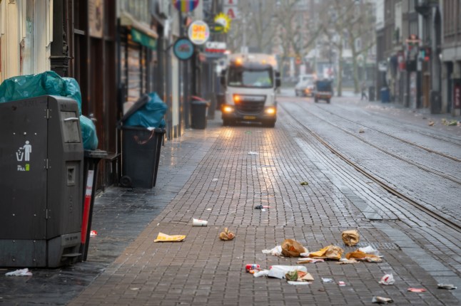 Messy street with garbage truck in city