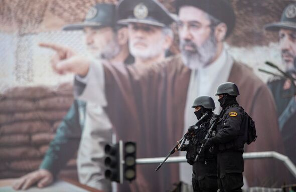 A billboard shows a graphic depicting Iran's Supreme Leader Ayatollah Mojtaba Khamenei with military commanders as people attend the annual anti-Israe