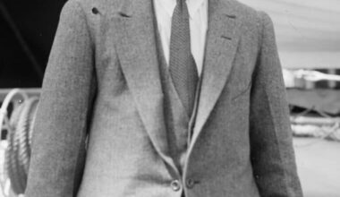 Black-and-white portrait of Welsh flyweight boxer Jimmy Wilde standing on the deck of a ship wearing a suit and tie, circa 1920.