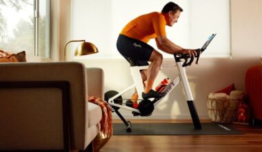 A man rides a Zwift Ride smart trainer in a living room