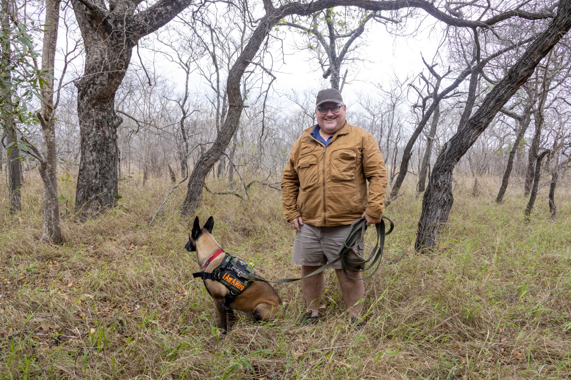 Ashwell Glasson stands with Yakos, a ranger dog wounded in anti‑poaching operations and retired due to injuries.