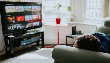 A person relaxes on a comfortable couch choosing a programme on a streaming service.