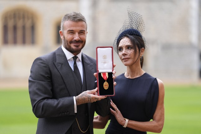 TOPSHOT - Former England footballer David Beckham (L) poses next to his wife singer and fashion designer Victoria Beckham (R) with his medal after being appointed as a Knight Bachelor (Knighthood) for services to sport and charity at an investiture ceremony at Windsor Castle on November 4, 2025. (Photo by Andrew Matthews / POOL / AFP) (Photo by ANDREW MATTHEWS/POOL/AFP via Getty Images)