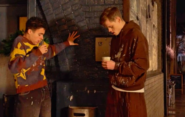 Oscar and Josh reel in shock as the former's milkshake is spilled all over them in EastEnders