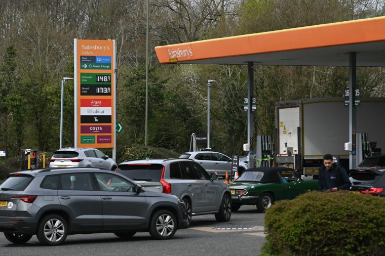 Drivers queue at a petrol service station in Cobham, south-west of London on March 29, 2026. The average price of unleaded petrol has risen by more than 17p a litre since the end of February to over ??1.50, according to fresh RAC data, as some petrol pumps are seeing shortages amid tight supply linked to the conflict in the Middle East. (Photo by JUSTIN TALLIS / AFP via Getty Images)