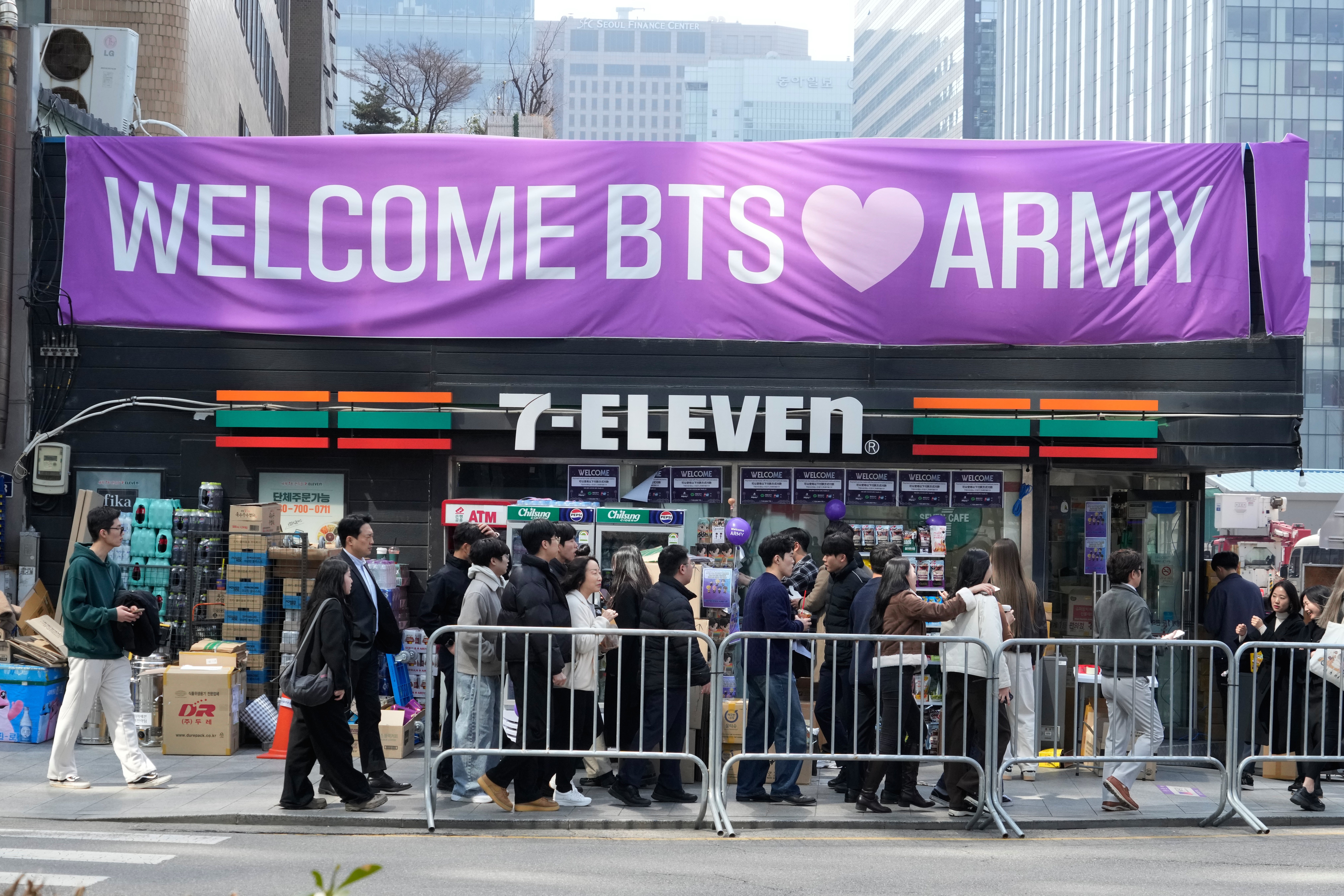 People pass by a banner for BTS ahead of a comeback concert of the K-pop band near Gwanghwamun Square in Seoul, South Korea, Friday, March 20, 2026. (AP Photo/Ahn Young-joon)