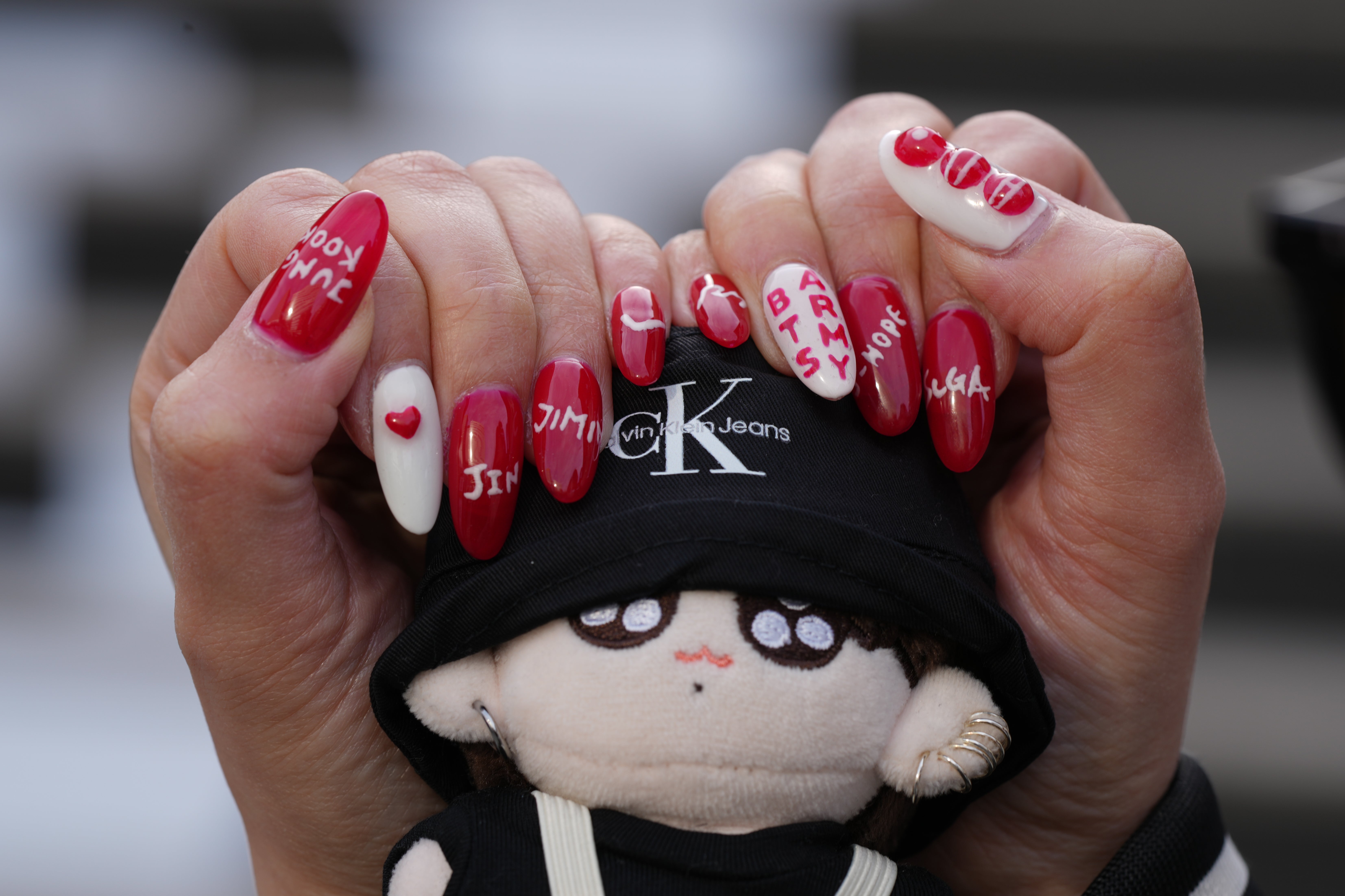 Yumika Ueno, a Japanese fan of K-pop band BTS, poses for a photo with her painted nails showing the names of BTS members at Gwanghwamun Square in Seoul, South Korea, Thursday, March 19, 2026. (AP Photo/Lee Jin-man)
