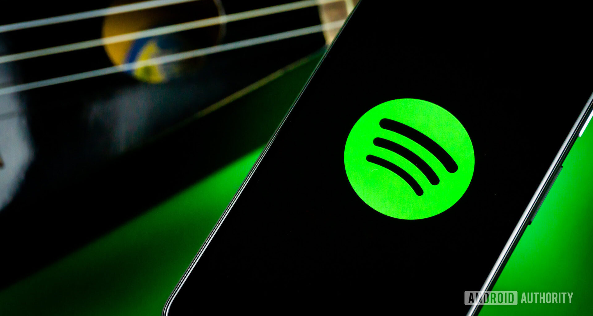 Spotify on a phone next to a guitar