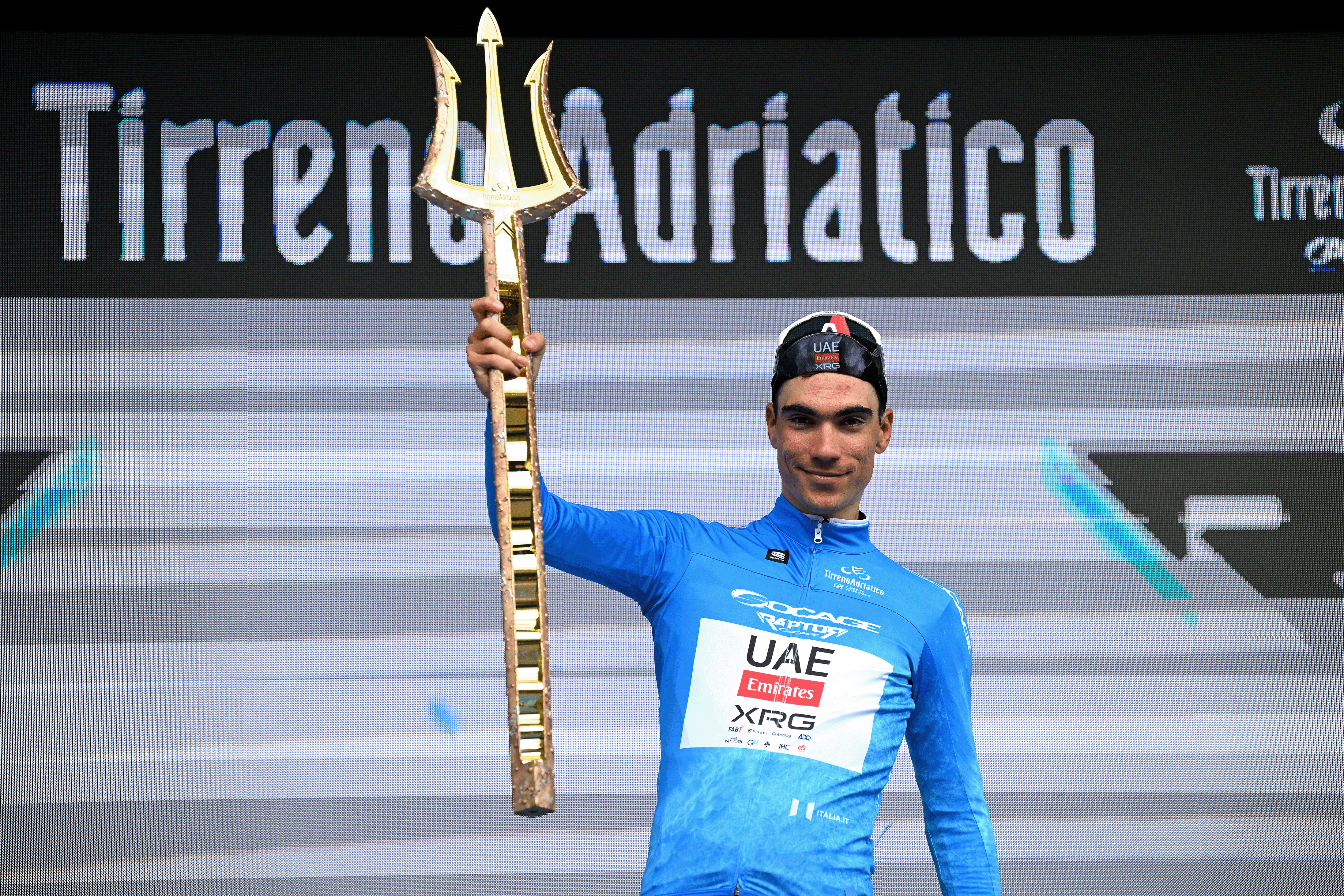 SAN BENEDETTO DEL TRONTO, ITALY - MARCH 16: Juan Ayuso Pesquera of Spain and UAE Team Emirates XRG - Blue Leader Jersey celebrates at podium as final overall race winner during the 60th Tirreno-Adriatico 2025, Stage 8 a 147km stage from Porto Potenza Picena to San Benedetto del Tronto / #UCIWT / on March 16, 2025 in San Benedetto del Tronto, Italy. (Photo by Tim de Waele/Getty Images