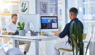 two men working on computers in office