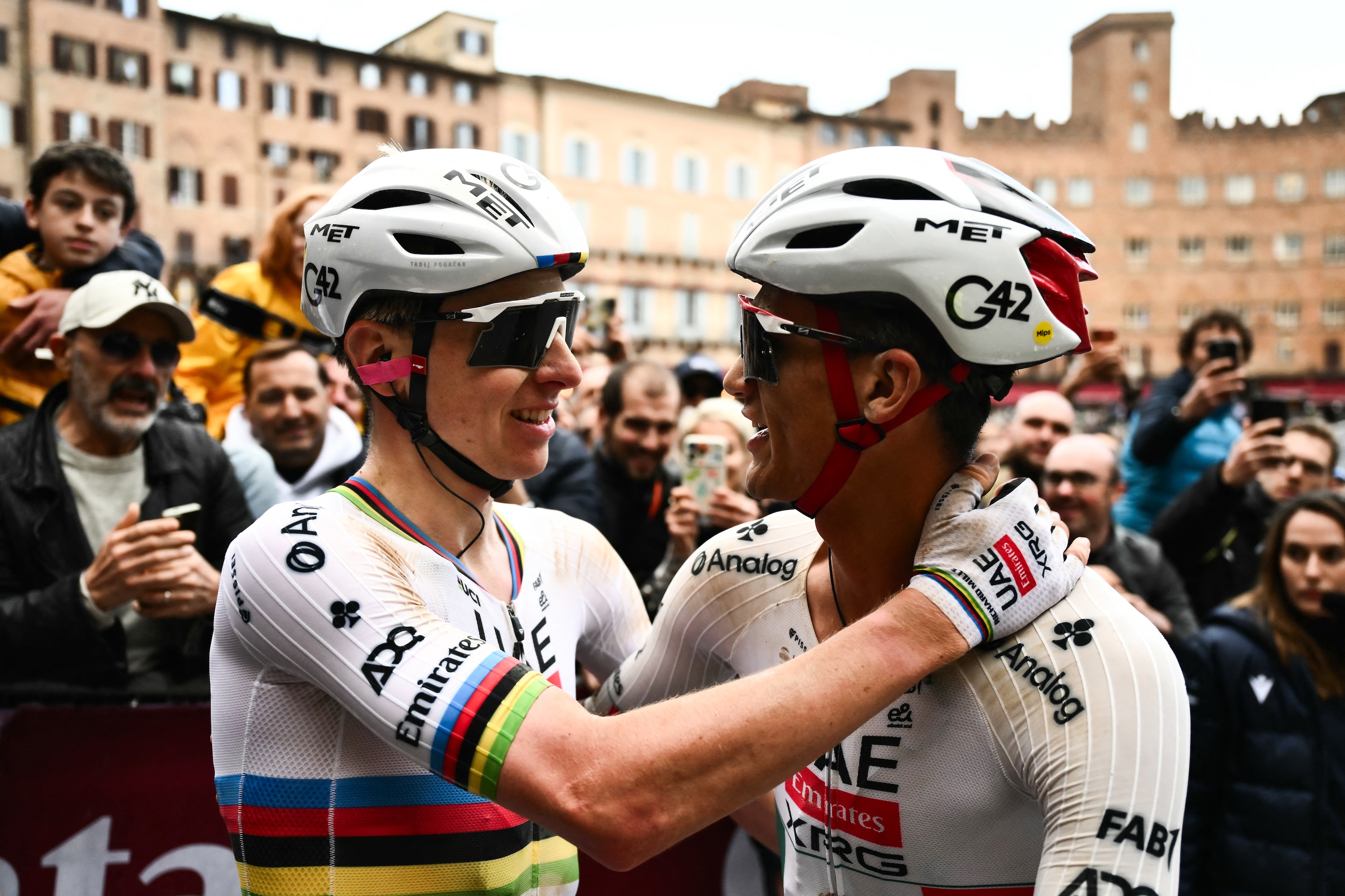 UAE Team Emirates's Slovenian Tadej Pogacar (L) celebrates with UAE Team Emirates's Mexican Isaac Del Toro Romero after winning the 20th one-day classic 'Strade Bianche' (White Roads) men's cycling race between Siena and Siena in Tuscany on March 7, 2026. (Photo by Marco BERTORELLO / AFP)