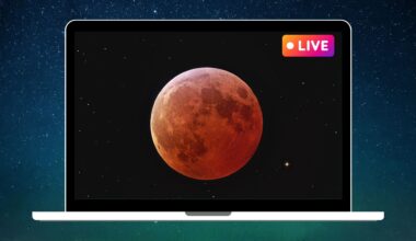 graphic showing a blood moon during a total lunar eclipse in the center of a laptop screen with a pink and yellow "live" sign in the top right corner.