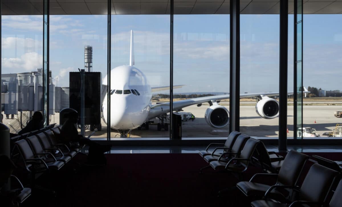 A Long Range Airliner Waiting Outside An Airport, Seen From Inside The Terminal, From A Waiting Room Where People Usually Wait To Check In And Board The Plane