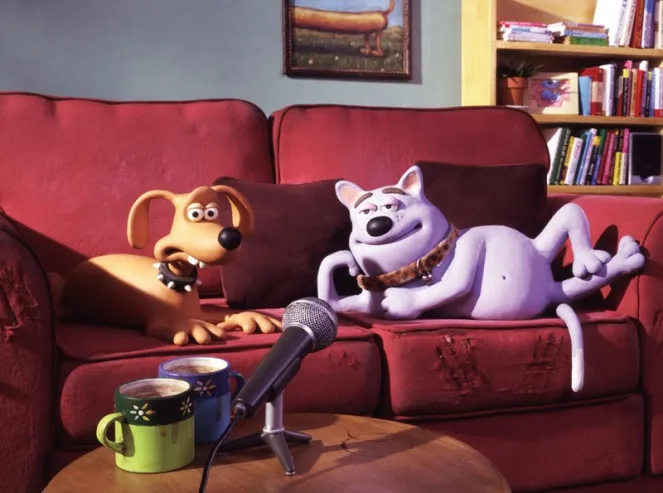 Illustration of two claymation dogs being interviewed on a couch for the Creature Comforts series.