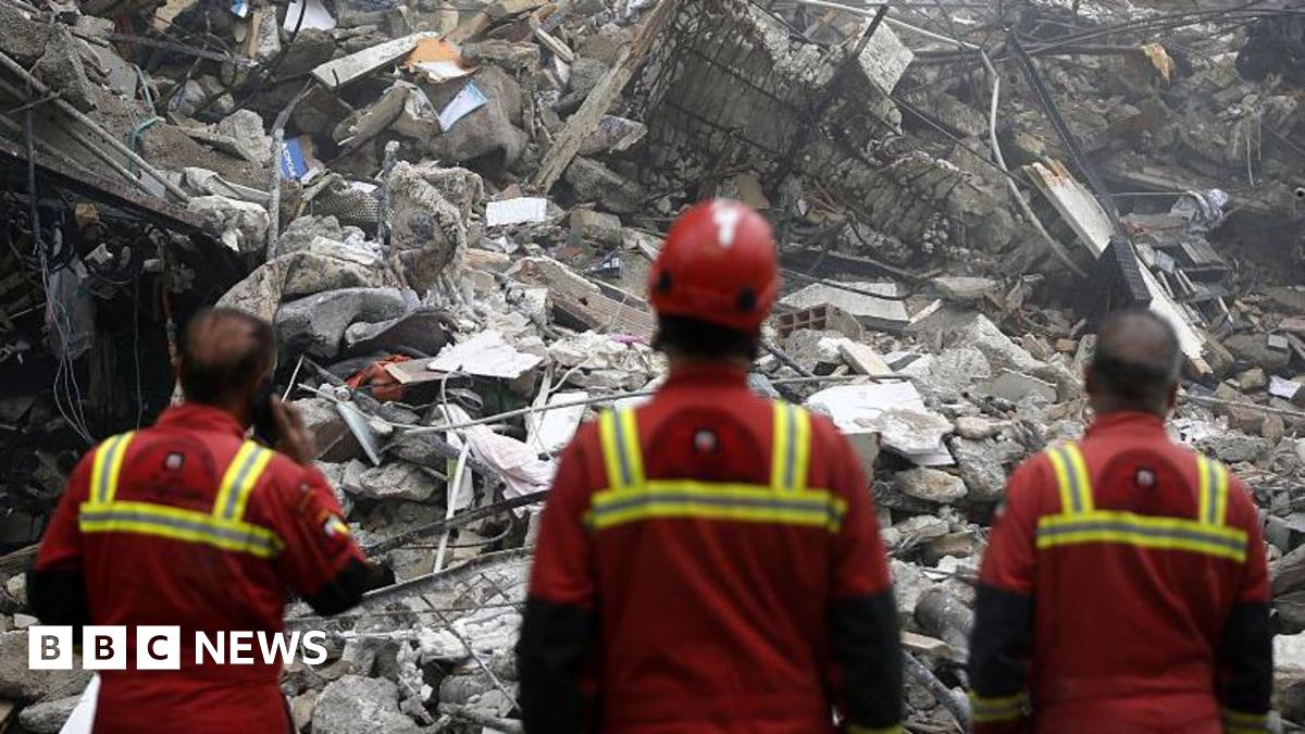 A woman in Tehran, Iran, stands in a bombed building looking out over piles of debris. Photo: 21 March 2026.